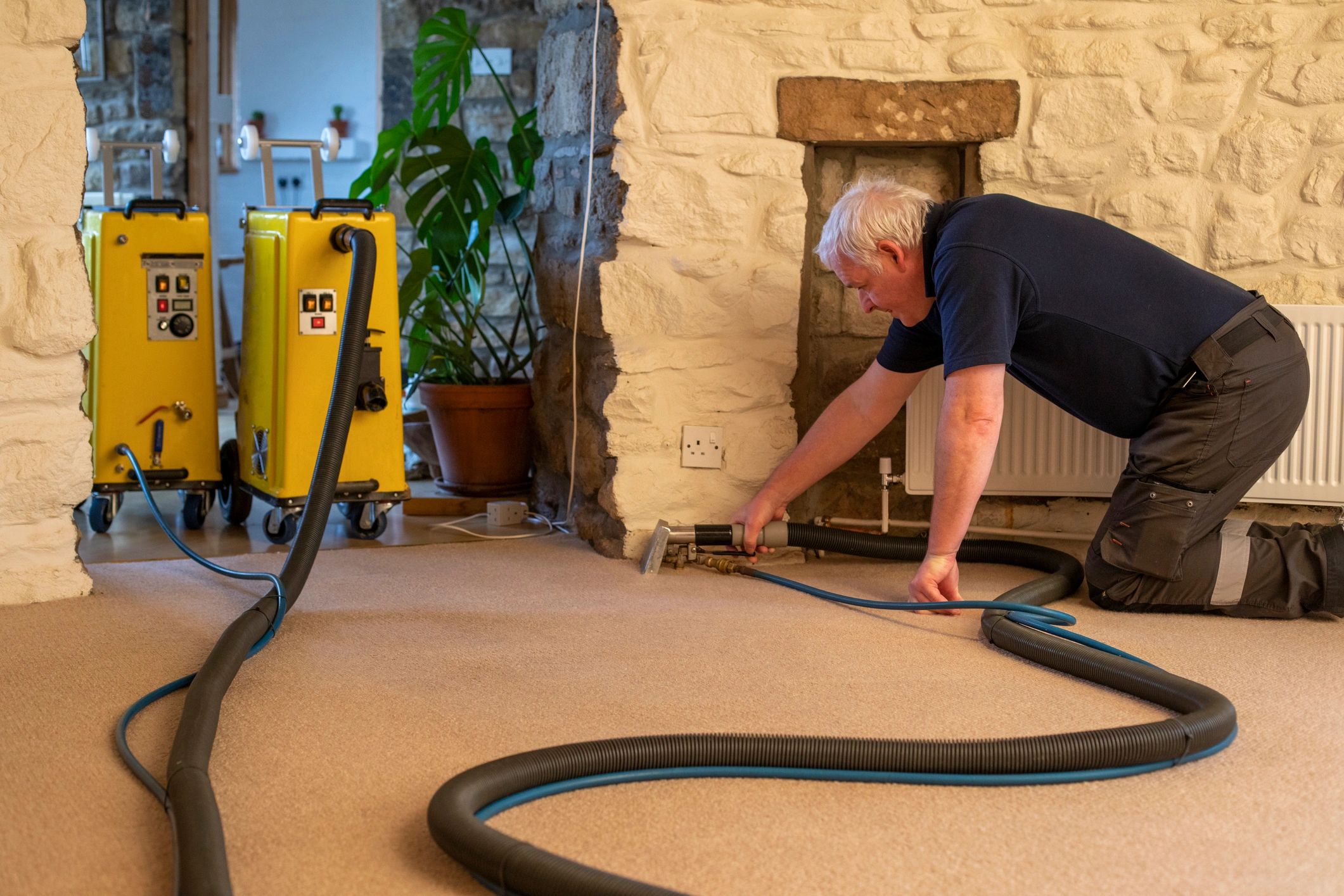 Commercial cleaner vacuuming carpet in an empty room